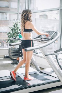 Koşu bandı üzerinde çalışan çekici kas gülümseyen fitness kadın i