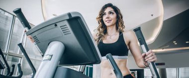 Koşu bandı üzerinde çalışan çekici kas gülümseyen fitness kadın i