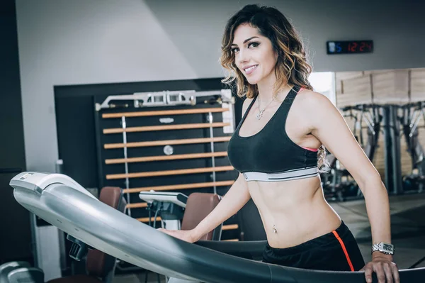 Attraktiva muskulös leende Fitness kvinna som kör på löpbandet jag — Stockfoto