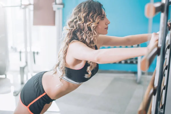 Atractiva mujer fitness muscular haciendo ejercicio duro en moderno —  Fotos de Stock