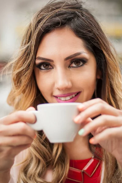 Portrait of woman sitting in outdoor cafe and drinking coffee — Stock Photo, Image