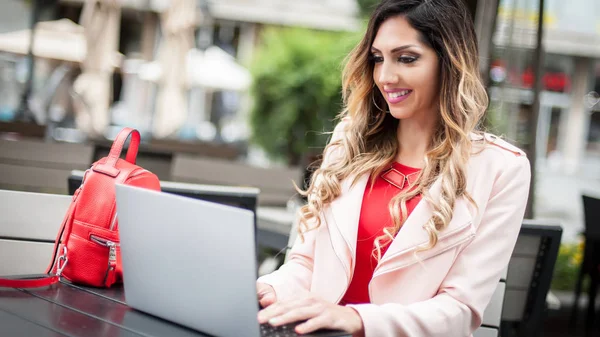 Joven blogger freelancer en cafetería al aire libre con lapicera de computadora — Foto de Stock