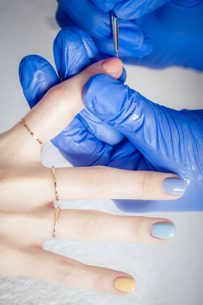 Female manicurist master applying nail polish in beauty salon