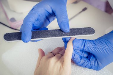 Tırnak file ile bir güzellik tarafından manikür alan kadın