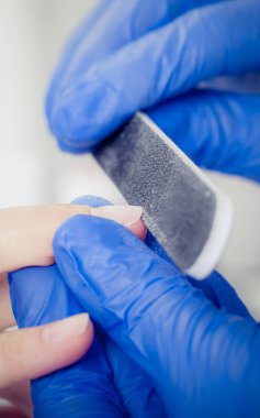 Tırnak file ile bir güzellik tarafından manikür alan kadın