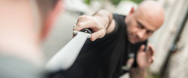 Eskrima ve kapap eğitmen pala silah dövüşmeni gösterir