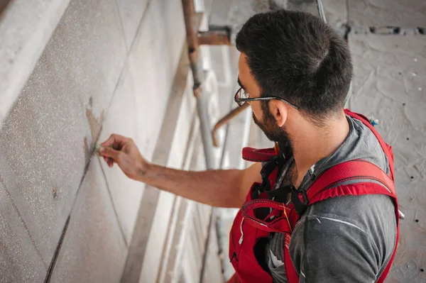 Mann steht auf Gerüst und restauriert alte Hausfassade — Stockfoto