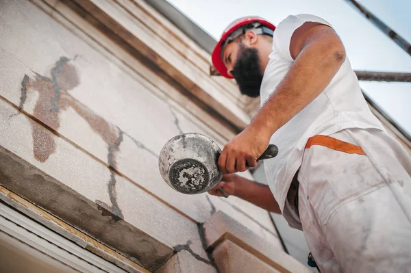 Mann steht auf Gerüst und restauriert alte Hausfassade — Stockfoto