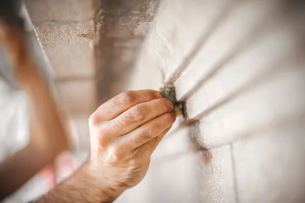 古い建物の壁を漆喰男の手の閉じる — ストック写真