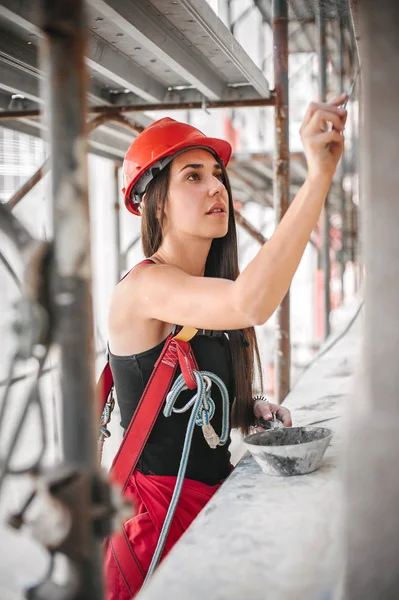 Arbeiterin verputzt alte Hauswand mit Zementputzmischung — Stockfoto