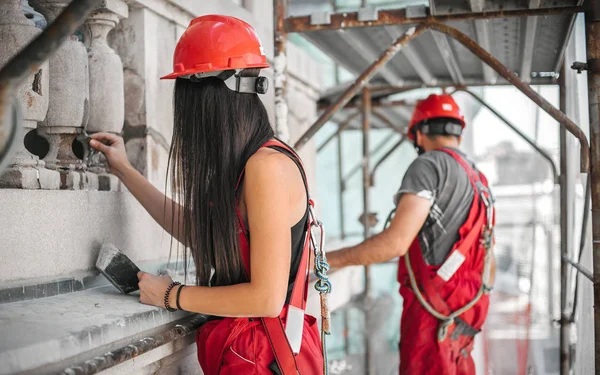 Zwei Arbeiter stehen auf Baugerüsten und restaurieren alte Fassade — Stockfoto