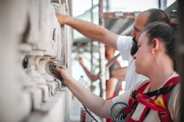 Zwei Arbeiter stehen auf Baugerüsten und restaurieren alte Fassade — Stockfoto