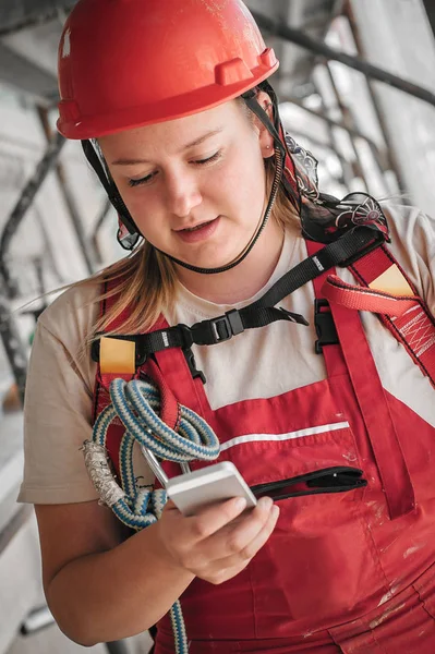Bauarbeiterin auf dem Gerüst mit Handy — Stockfoto