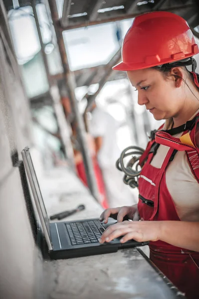 Ingeniera arquitecta inspecciona el sitio de construcción en computadora portátil — Foto de Stock