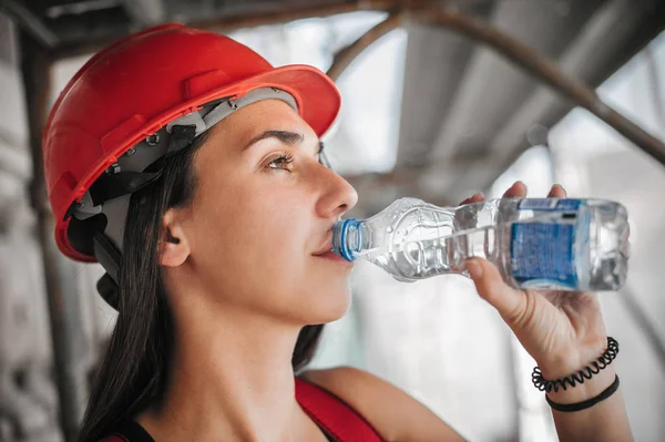 Trabajadora de albañil de construcción sobre andamios, reposo y agua potable — Foto de Stock