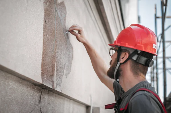 Mann steht auf Gerüst und restauriert alte Hausfassade — Stockfoto