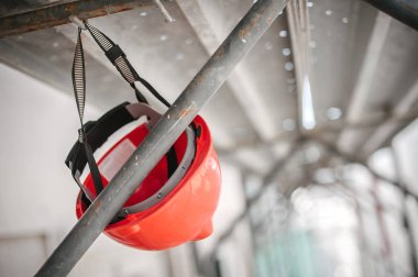 İnşaat sahasında güvenlik kaskı. İskele ve çalışma araçları var.