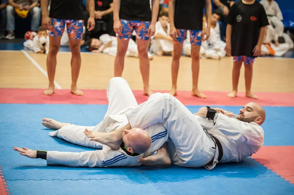 Instrutor de arte marcial do BJJ demonstra técnicas brasileiras de luta no solo de jiu-jitsu — Fotografia de Stock