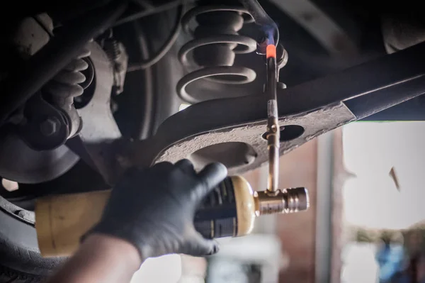 Car master mechanic repairer heating the screws with flamethrowe — Stock Photo, Image