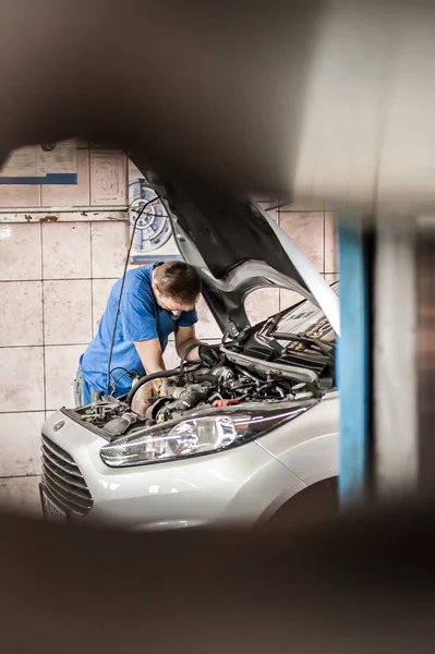 Car mechanic repairer service technician checks and repairs auto