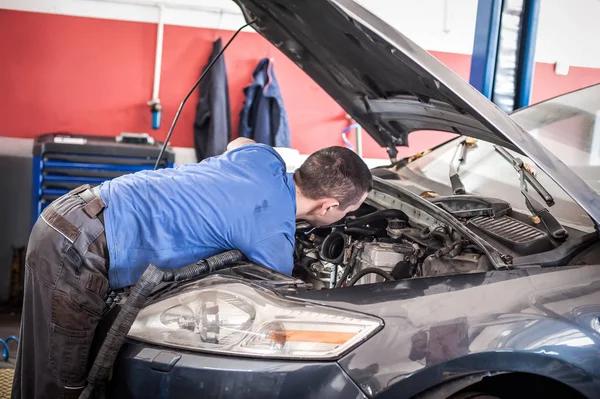 Car mechanic repairer service technician checks and repairs auto