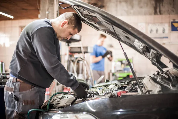 Dos reparadores mecánicos de automóviles técnico de servicio reparaciones auto engin —  Fotos de Stock