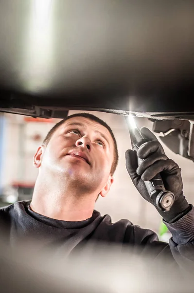 Reparador mecánico de automóviles que comprueba la condición bajo coche en el vehículo l —  Fotos de Stock