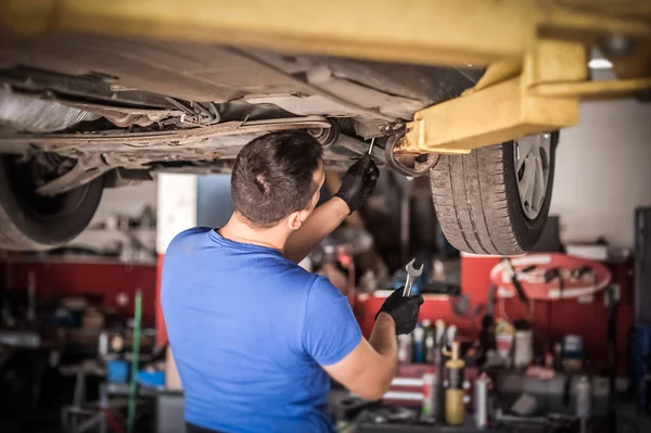 Auto mechanic repairer checking condition under car on vehicle l — Stock Photo, Image