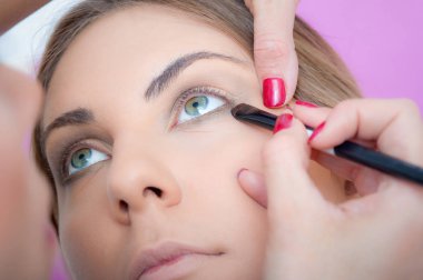 Makyaj sanatçısı temel renk göz farı uyguluyor