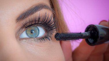 Makyaj sanatçısı model e 'nin kirpiklerine rimel sürüyor