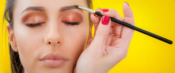 Makijażysta nakładanie makijażu na twarz za pomocą szczotki proszku — Zdjęcie stockowe