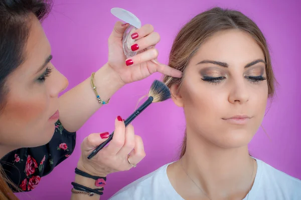 Makijażysta nakładanie makijażu na twarz za pomocą szczotki proszku — Zdjęcie stockowe
