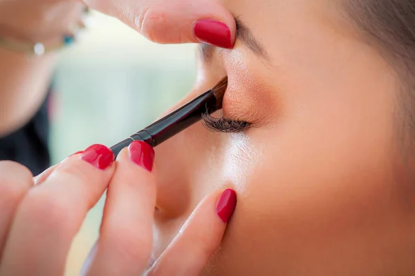 Maquillaje artista profesional aplicando sombra de ojos de color base en modo — Foto de Stock