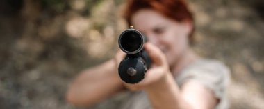 Woman shooting with pump gun. Direct macro detail close-up shotgun front view gun point. Firearm shooting and weapons training. Shooting range clipart