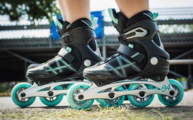 Dişi bacaklar inline patenlerle hareket halinde. Olağanüstü bir spor. Spor ve eğlence kavramı. Spor yaşam tarzı. Eğlenceli zaman aktivitesi