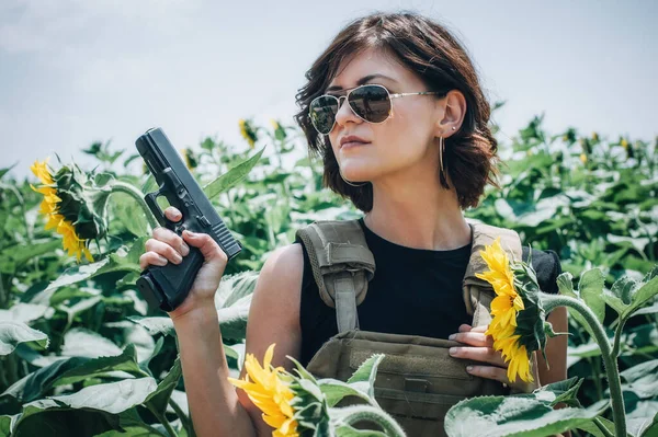 Silahlı güzel ve çekici bir kadın asker. Silahlı bir kadın. Atış poligonu talimi. Moda modeli tarzı