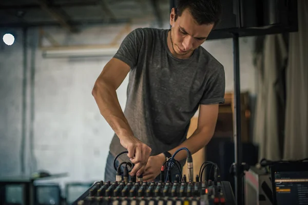 Behind the scene. Sound technician electric engineer adjusting sound elements backstage. Control audio panel. Audio mixing console