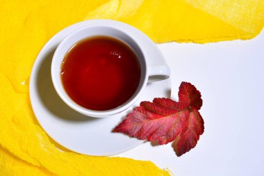 beyaz fincan sıcak çay ve akçaağaç yaprağı