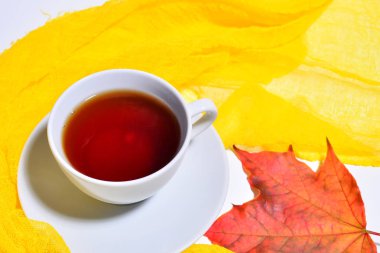 beyaz fincan sıcak çay ve akçaağaç yaprağı