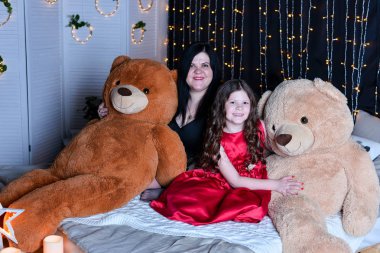 Güzel kız ve annesi evde yatakta poz