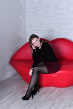 genç güzel kadın kanepe dudak şeklinde poz 