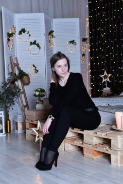 Genç ve güzel bir kadın evde yatakta oturuyor.