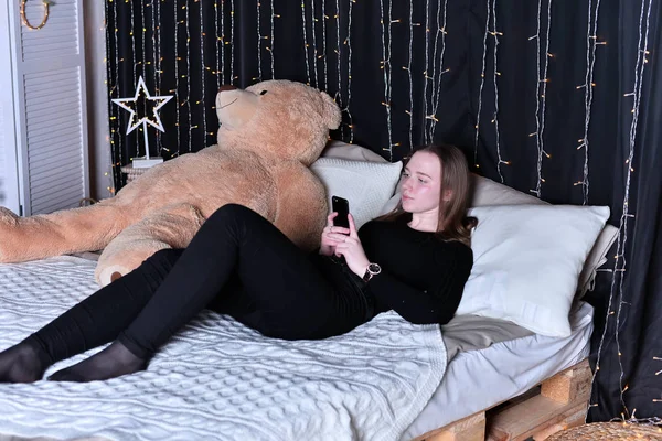 young beautiful woman with smartphone    on bed at home