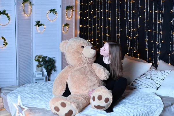 young beautiful woman posing   with big teddy bear