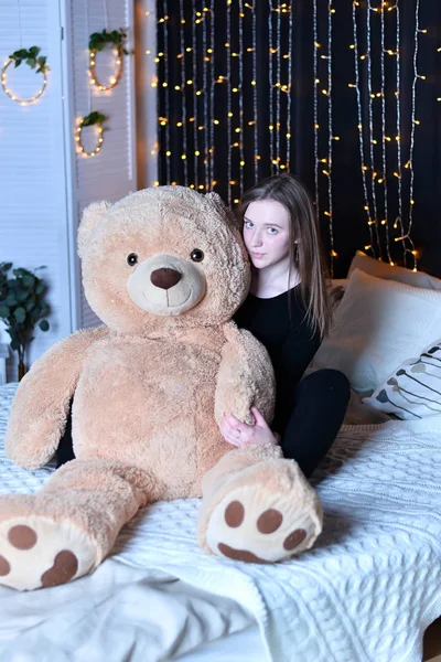 young beautiful woman posing   with big teddy bear