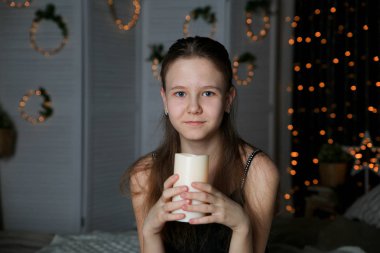 Güzel şirin kız yatakta evde mum ile poz