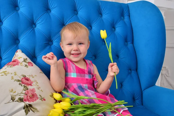 小女孩与美丽的郁金香在室内 — 图库照片
