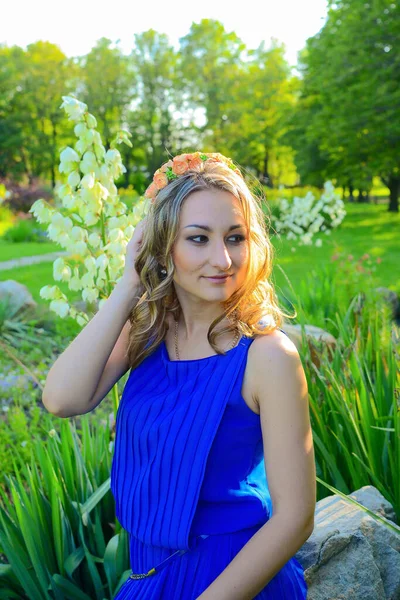 穿着蓝色衣服的年轻漂亮的姑娘在夏日的公园里摆姿势 — 图库照片