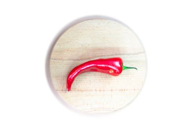Acı biber ve izole beyaz bir arka plan üzerinde ahşap bir tahta üzerinde çiy bir damla