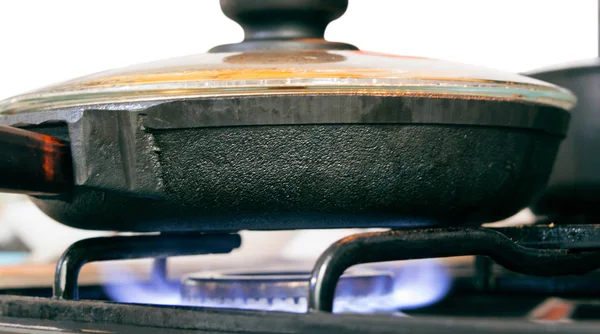 Cast iron pan with food on the stove with fire